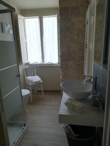 a bathroom with a sink and a tub and a window at Appartamento il castellare in Rapolano Terme