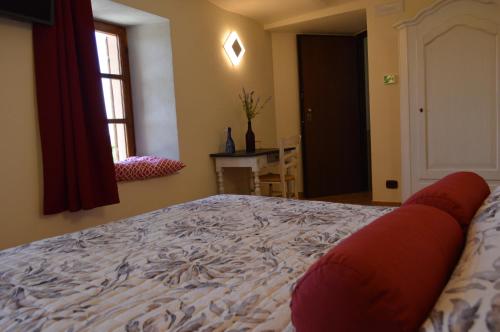 a bedroom with a large bed and a window at Casa Pulci in Grinzane Cavour