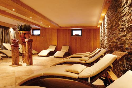 a room with a row of chairs and a stone wall at Appartement Stelo Gosau-Hallstatt in Gosau