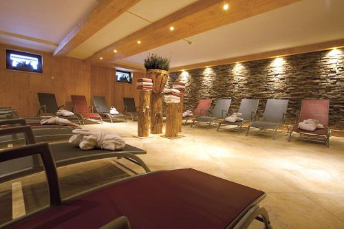 a room with rows of chairs and a stone wall at Appartement Stelo Gosau-Hallstatt in Gosau