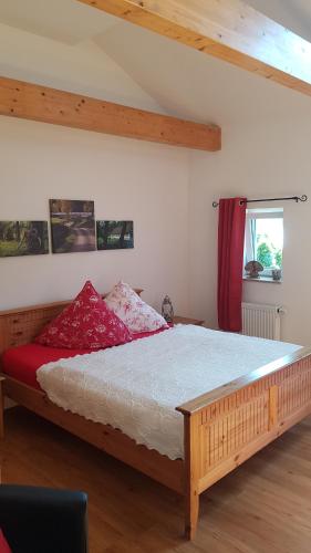 a bedroom with a large wooden bed with red pillows at Fewo Leest No.1 in Werder