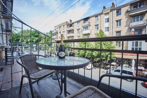a table with a bottle of wine on a balcony at Langery Residence Central Apartments in Odesa