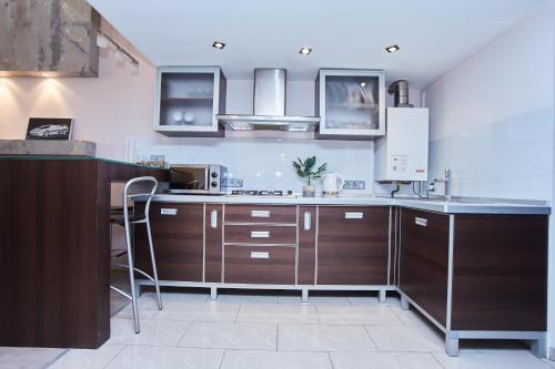 a kitchen with wooden cabinets and a counter top at Langery Residence Central Apartments in Odesa