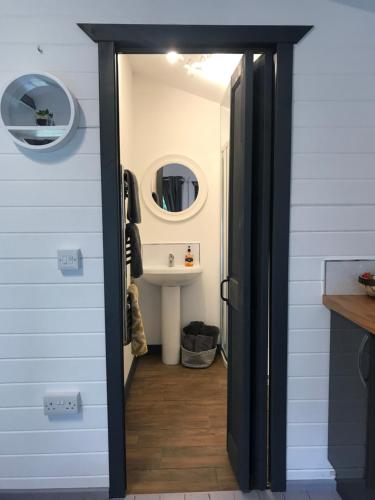 a door leading into a bathroom with a sink at Star Cabin Lairg in Lairg