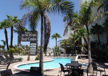 a swimming pool with chairs and a sign in a resort at Sunchase Inn & Suites in South Padre Island