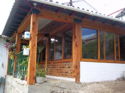 a wooden screened in porch with a roof at HOSPEDAJE BELLA VISTA MONGUI in Monguí