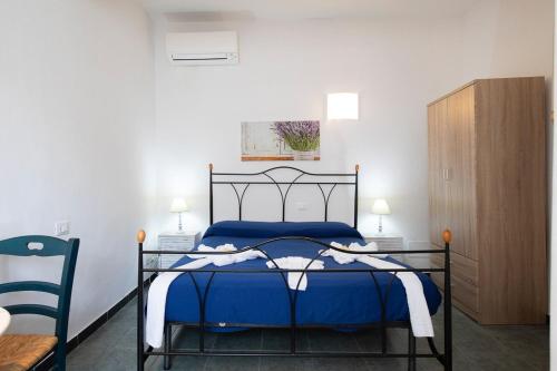 1 dormitorio con 1 cama azul y armario de madera en The 5 Terre, en Riomaggiore