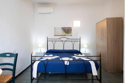 a bedroom with a blue bed and a wooden cabinet at The 5 Terre in Riomaggiore