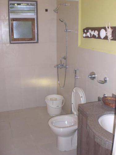 a bathroom with a toilet and a sink at A's Holiday Beach Resort in Betalbatim
