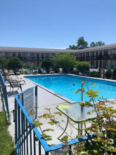 a large swimming pool with a table in front of a building at Niagara Lodge & Suites in Niagara Falls