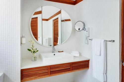 a bathroom with a sink and a mirror at Couples Swept Away in Negril