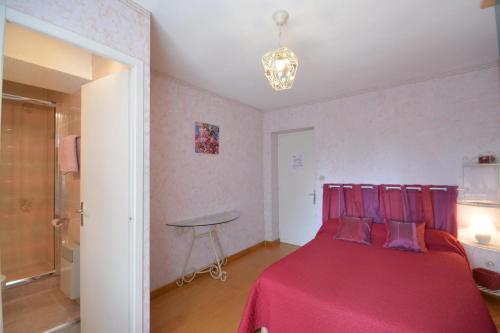 a bedroom with a red bed with purple pillows at Chambre d'Hôtes Au Vieux Chêne in Grillon