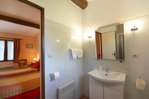 a bathroom with a sink and a mirror and a tub at Chambre d'Hôtes Au Vieux Chêne in Grillon