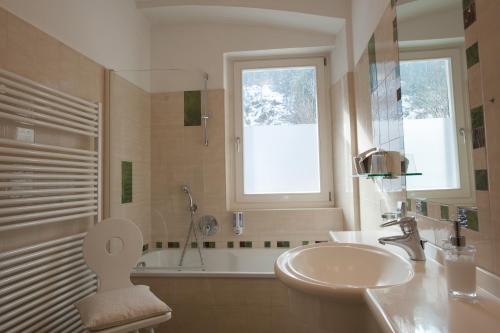 a bathroom with a sink and a toilet and a tub at Parkhotel Sole Paradiso in San Candido