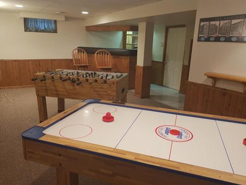 Una habitación con una mesa de ping pong y sillas. en Sarnia's Man Cave welcomes you... Game ON!, en Sarnia