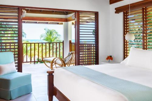 a bedroom with a bed and a view of the ocean at Couples Swept Away in Negril
