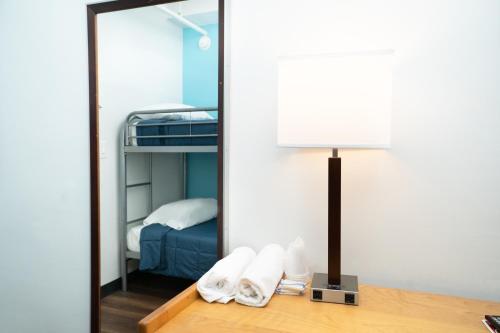 a mirror in a room with a bed and a lamp at West Side YMCA in New York