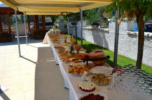 a long table filled with plates of food under a tent at Hotel Bucaneve in Pescasseroli
