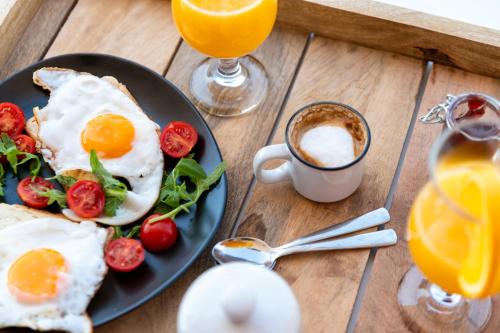 マンドレにあるVilla Natura luxury apartmentsの卵とトマトの皿とコーヒー一杯