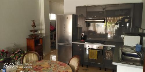 een keuken met een roestvrijstalen koelkast en een tafel bij soleil de Pirae in Pirae