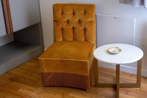a orange chair and a table with a bowl on it at ATHENIAN YARD SUITES in Athens