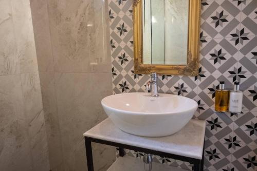 a bathroom with a white sink and a mirror at ATHENIAN YARD SUITES in Athens