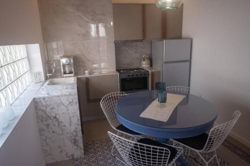 a small kitchen with a blue table and chairs at ATHENIAN YARD SUITES in Athens