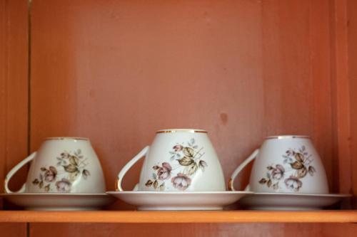 three cups and saucers sitting on a shelf at ATHENIAN YARD SUITES in Athens