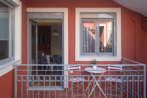 a balcony with chairs and a table and a window at ATHENIAN YARD SUITES in Athens
