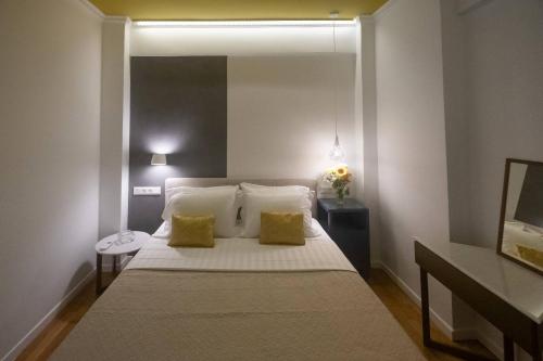 a bedroom with a large bed with two yellow pillows at ATHENIAN YARD SUITES in Athens