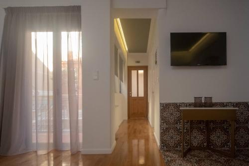 a living room with a couch and a television on a wall at ATHENIAN YARD SUITES in Athens
