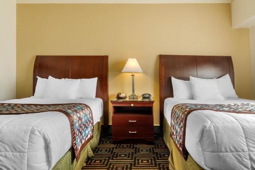 a hotel room with two beds and a table with a lamp at Inn at the Highland Denver Downtown in Denver