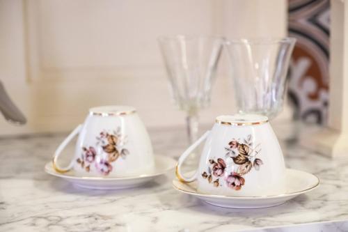 two tea cups on a counter with a vase at ATHENIAN YARD SUITES in Athens