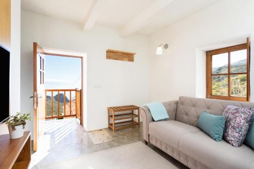 a living room with a couch and a balcony at Home2Book Nature Carrizales and Masca House & Wifi in Buenavista del Norte