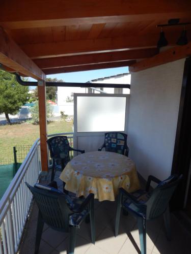 a patio with a table and chairs on a porch at Apartman Duje in Petrcane
