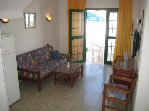 a living room with a couch and a table at Bungalows Boston in Puerto Rico de Gran Canaria