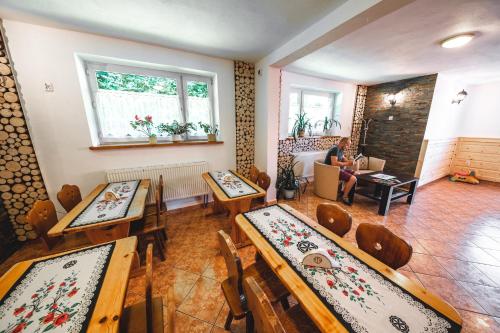 a room with tables and chairs and a person sitting in a couch at Hostel & Apartments u Florka 2 in Zakopane