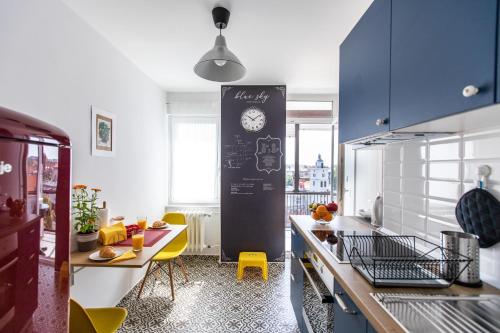 a kitchen with a table and a clock on the wall at Blue Sky Apartment in Zagreb
