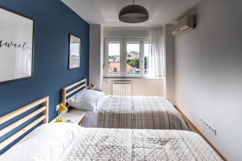 2 camas en un dormitorio con paredes azules en Blue Sky Apartment, en Zagreb