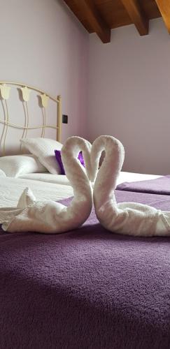 two towel swans are laying on a bed at Posada La Fabula in Santillana del Mar