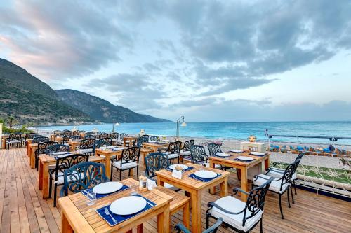 a restaurant with tables and chairs on the beach at Jade Residence in Oludeniz