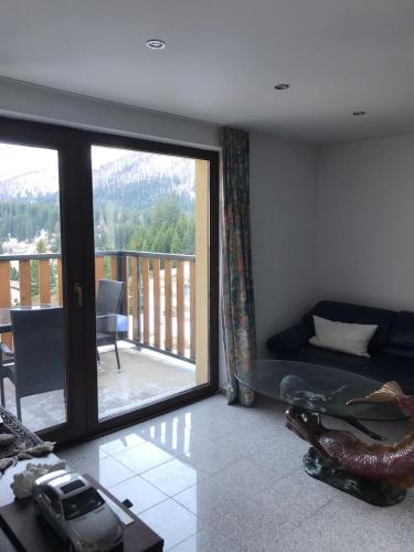 a living room with a couch and a balcony at Appartamenti Panorama in San Bernardino
