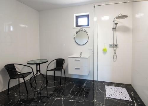 a bathroom with two chairs and a table and a shower at Willa Liski in Stare Juchy
