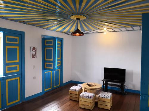 sala de estar con techo azul y amarillo en Hotel Salento 1842, en Salento