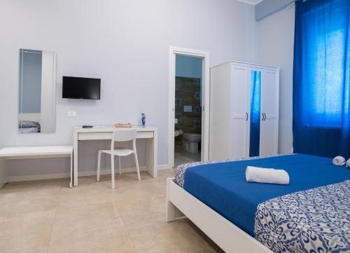 a bedroom with a bed and a desk and a table at Le Stanze Dell'Emiro in Palermo