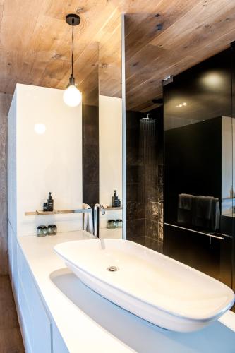a bathroom with a white sink and a mirror at POD Camps Bay by The Oyster Collection in Cape Town