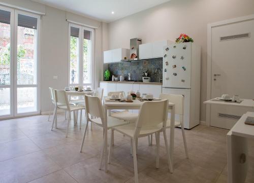una cucina con tavolo, sedie e frigorifero di Le Stanze Dell'Emiro a Palermo