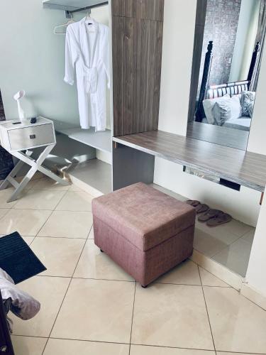 a dressing room with a mirror and a stool at Trendy apartments in Entebbe
