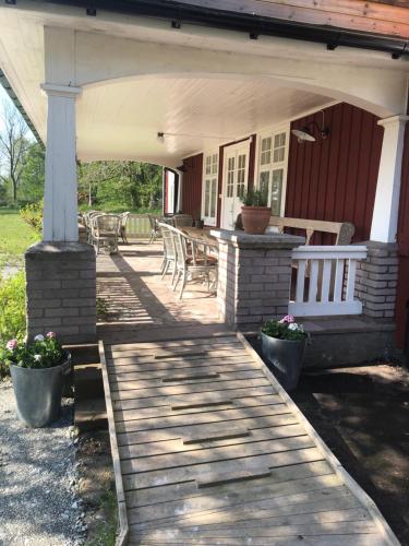 a porch of a house with a wooden deck at Pensionat Haga Öland in Löttorp