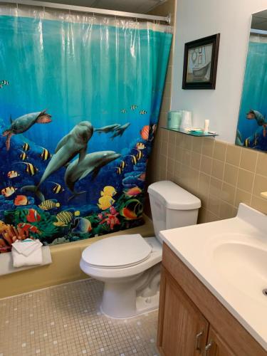 a bathroom with an aquarium shower curtain with a toilet at Roman Holiday Resort in North Wildwood
